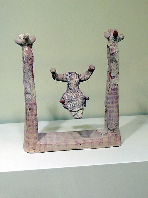 Heel oud beeldje van een vrouw op een schommel