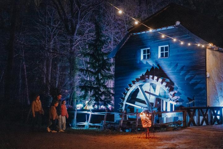 Gezin wandelt richting de verlichte watermolen