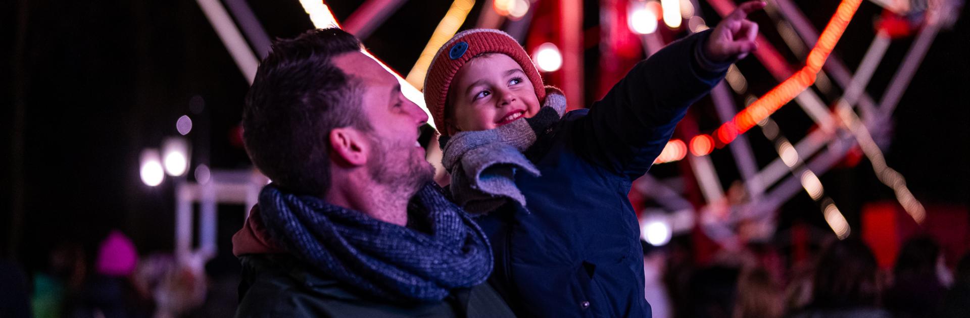 Papa en zoon op nostalgische kermis tijdens Winterlicht