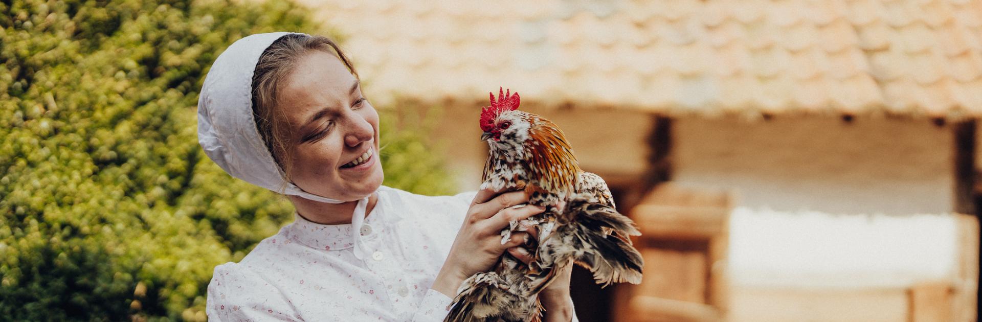 Living History actrice - boerin - met een kip in de handen