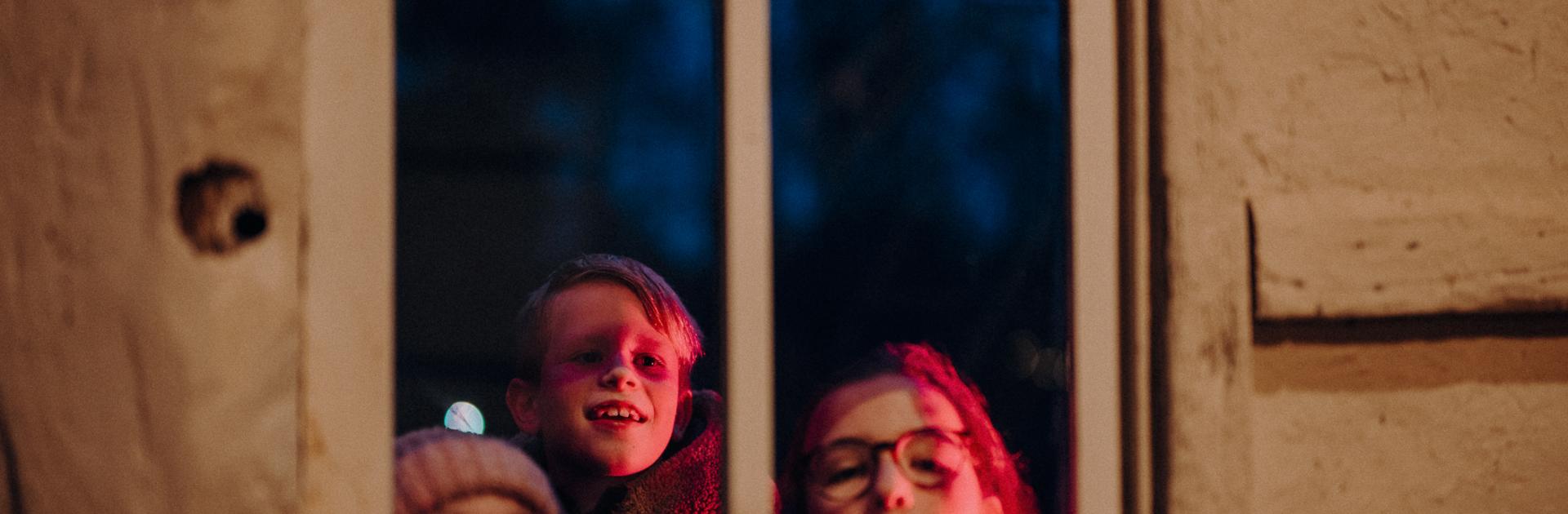 kinderen kijken door een raam tijdens Winterlicht