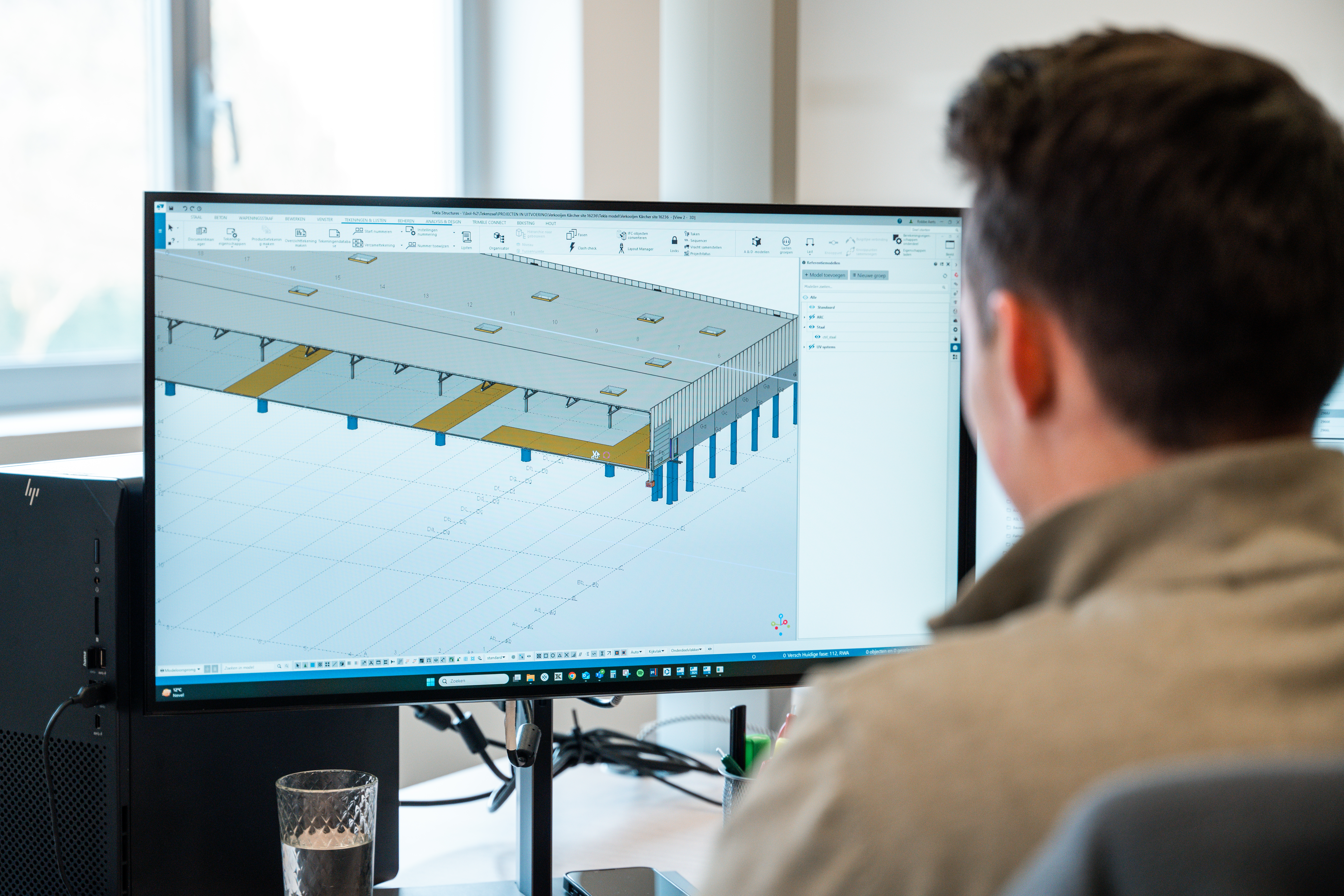 foto over schouder tekenaar met 3D op scherm