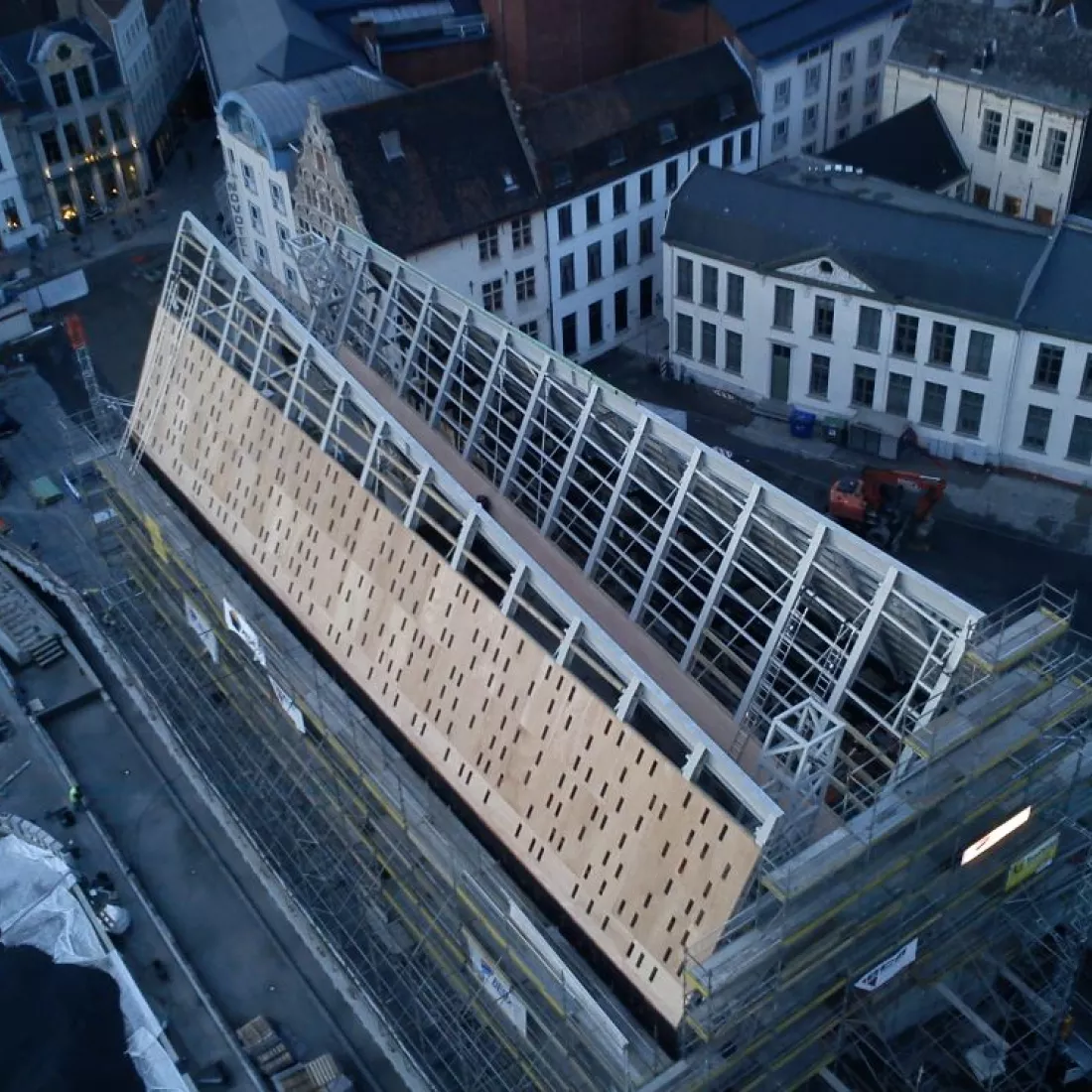Bovenaanzicht staalstructuur Kobra. De stalen constructie rust op vier betonnnen sokkels. Links zijn ze begonnen aan de opbouw van het dak tegen de stalenconstructie.