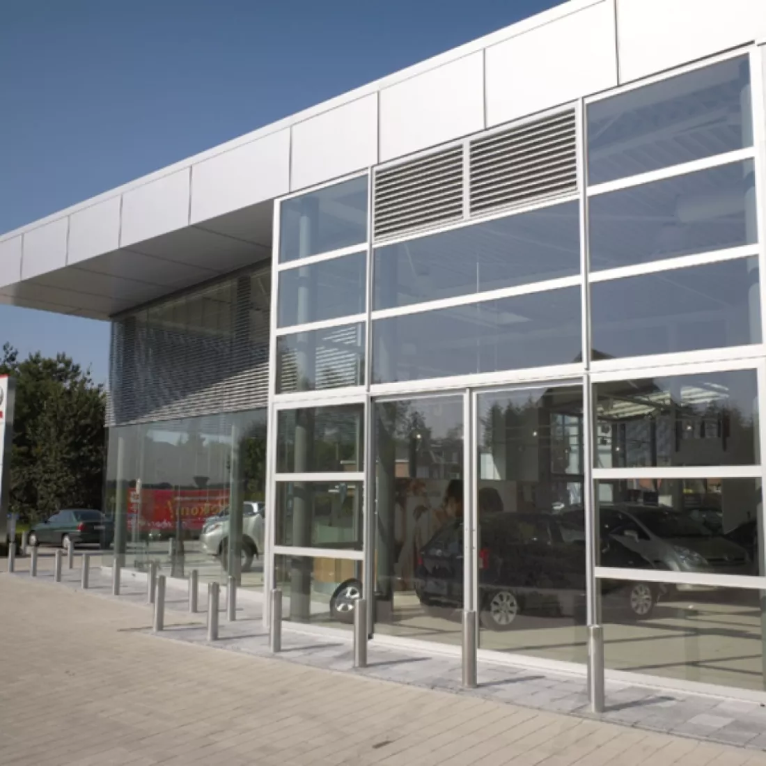 Zijaanzicht showroom garage Pieters. De showroom bestaat uit grote ramen en is opgebouwd met staal.