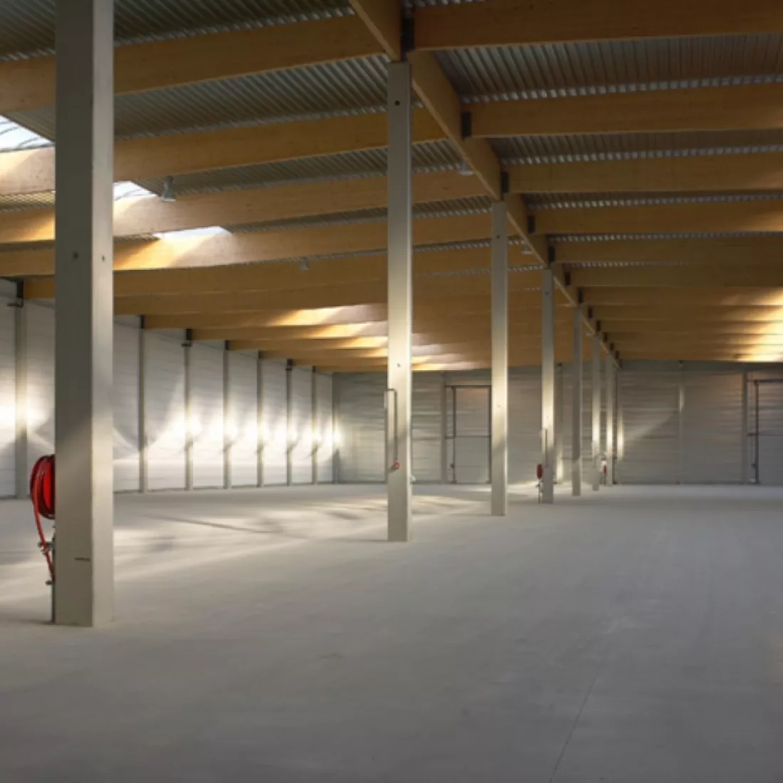 Binnenkant opslagloods - Mintjens. De loods bestaat uit een combinatie van materialen zoals hout en beton.