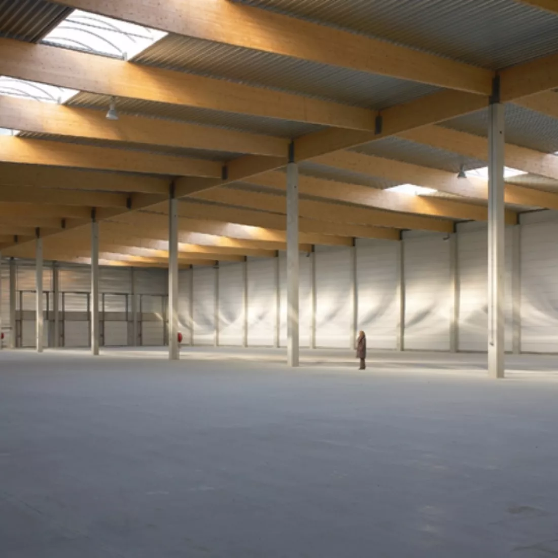 Binnenkant opslagloods - Mintjens. Achteraan rechts bevat de loods poorten. Het plafond bevat lichtstraten.