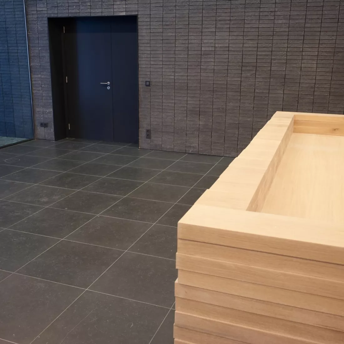 Binnenkant kantoor Cepa. De vloer en muren zijn zwart. Links in de achterste muur bevindt zich een zwarte deur.