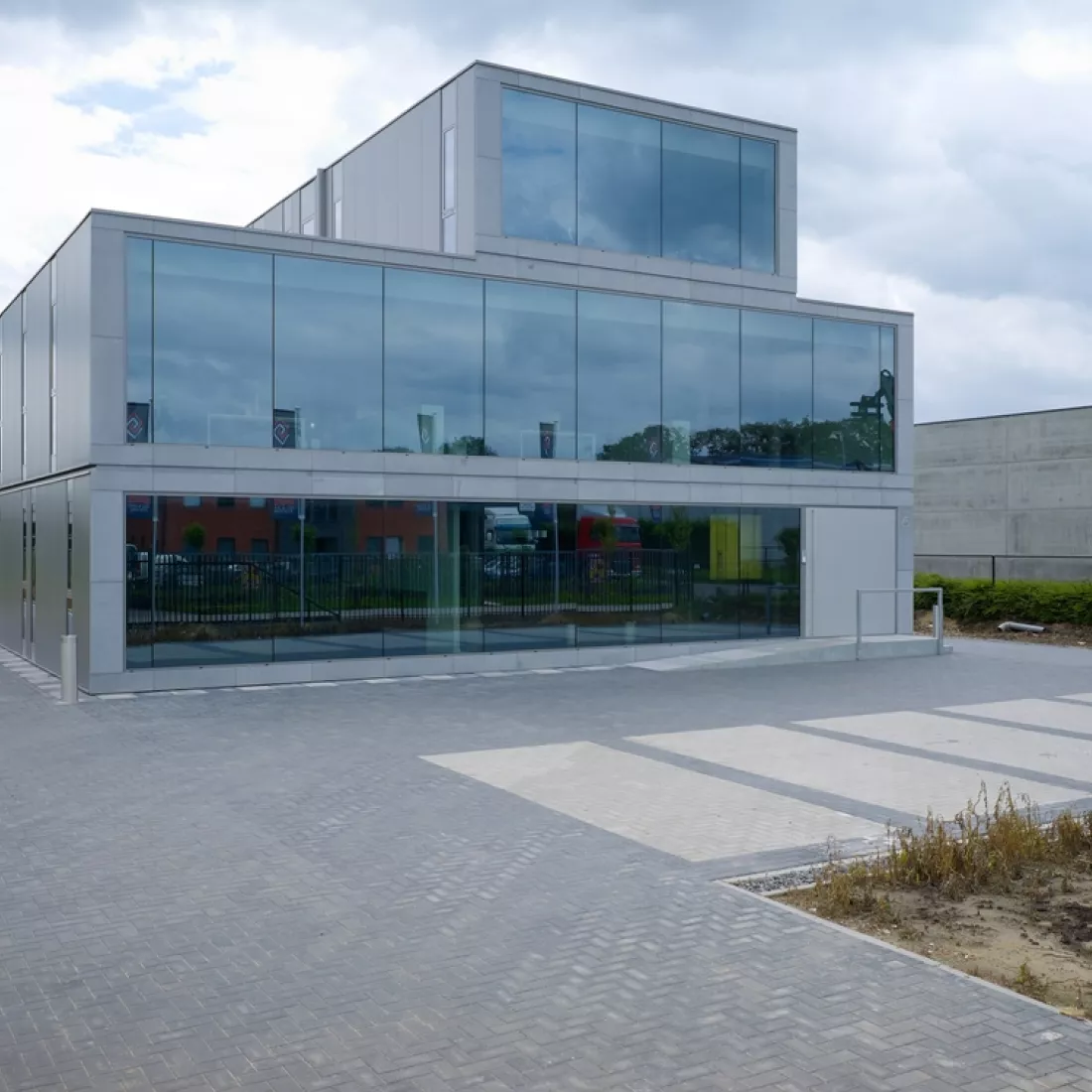 Vooraanzicht kantoor Global Gas Solutions. Het kantoor bevat drie verdiepingen. De bovenste verdieping is kleiner. Het gebouw bevat veel grote ramen.