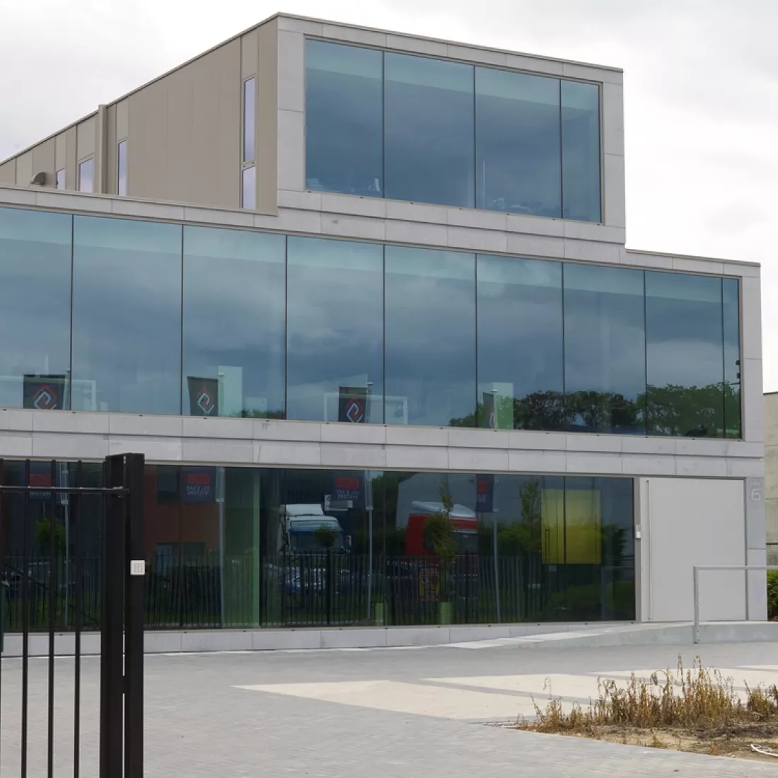 Vooraanzicht kantoor Global Gas Solutions. Het kantoor bevat drie verdiepingen. De bovenste verdieping is kleiner. Het gebouw bevat veel grote ramen.