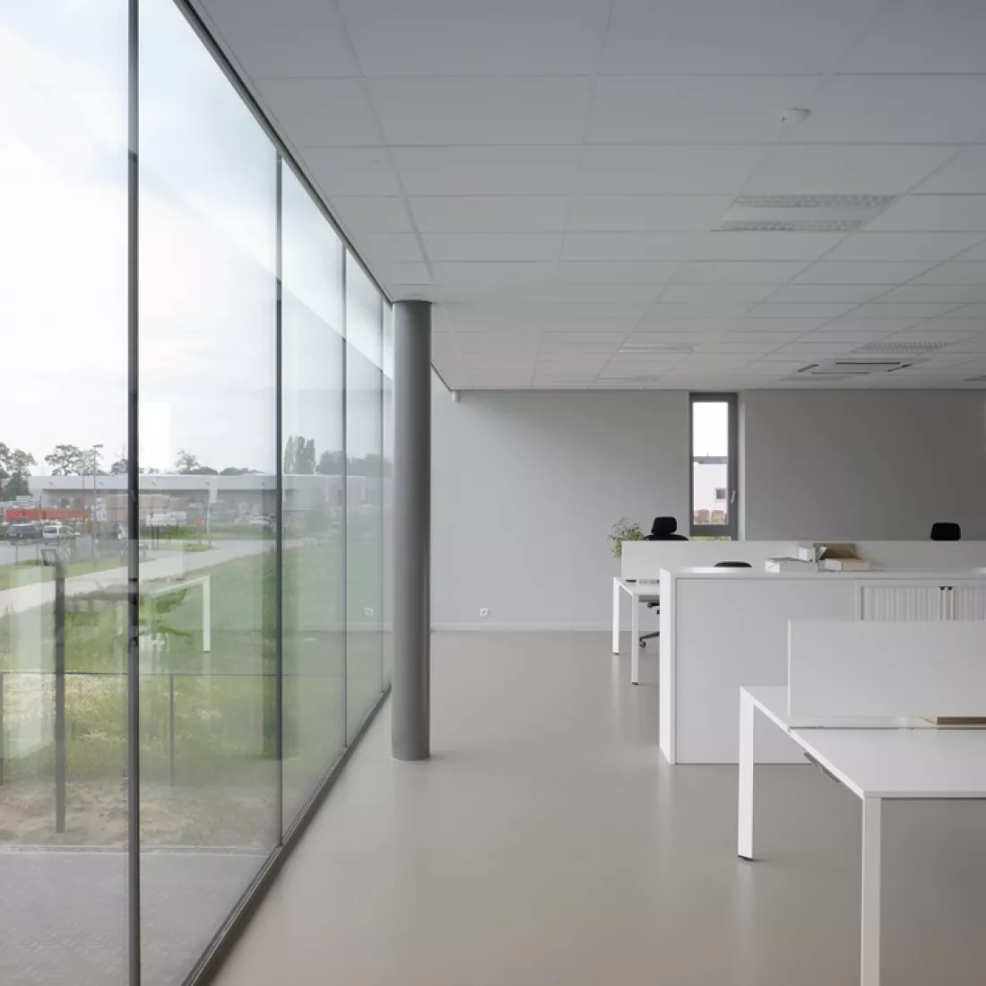 Binnenkant kantoor Global Gas Solutions. Links bevinden zich grote ramen. Rechts bevinden zich witte bureaus.
