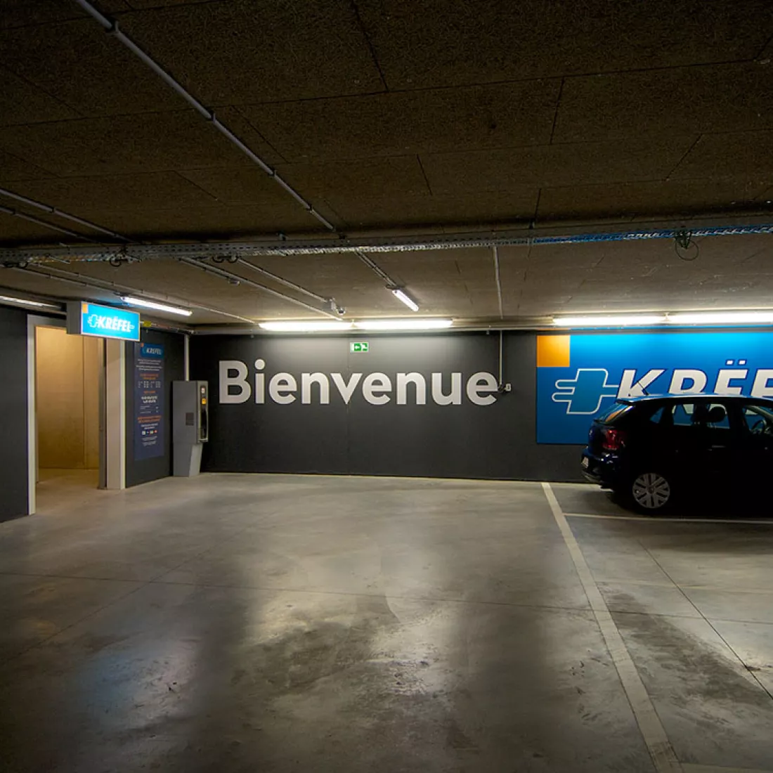 Garage Brussel met doorgang naar Krëfel. Links bevindt zich de doorgang naar de showroom en rechts zijn parkeerplaatsen.