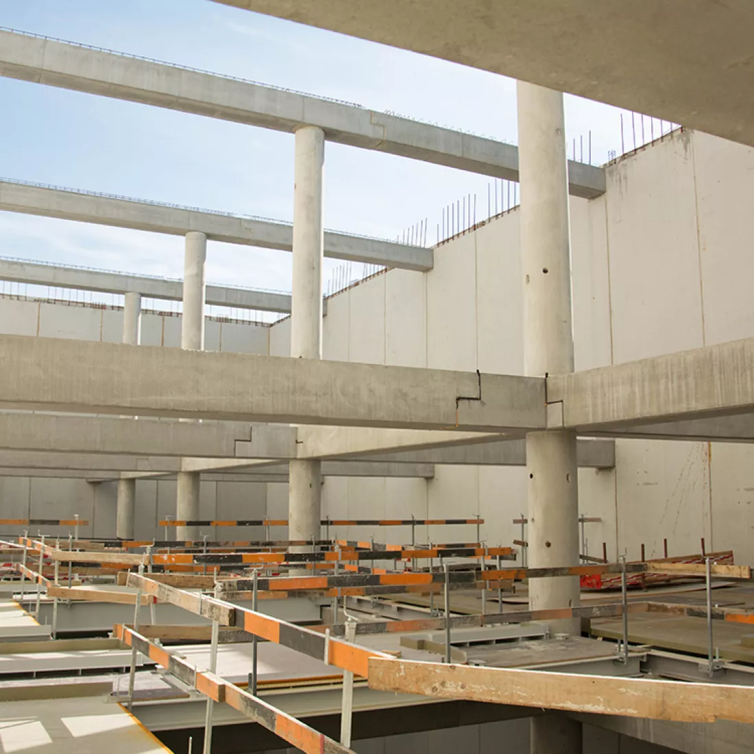 Opbouw nieuwbouw Milcobel. De afbeelding is langs de binnenkant genomen. De betonbouw is volledig in opbouw. Er zijn verschillende betonnen pilaren en balken.