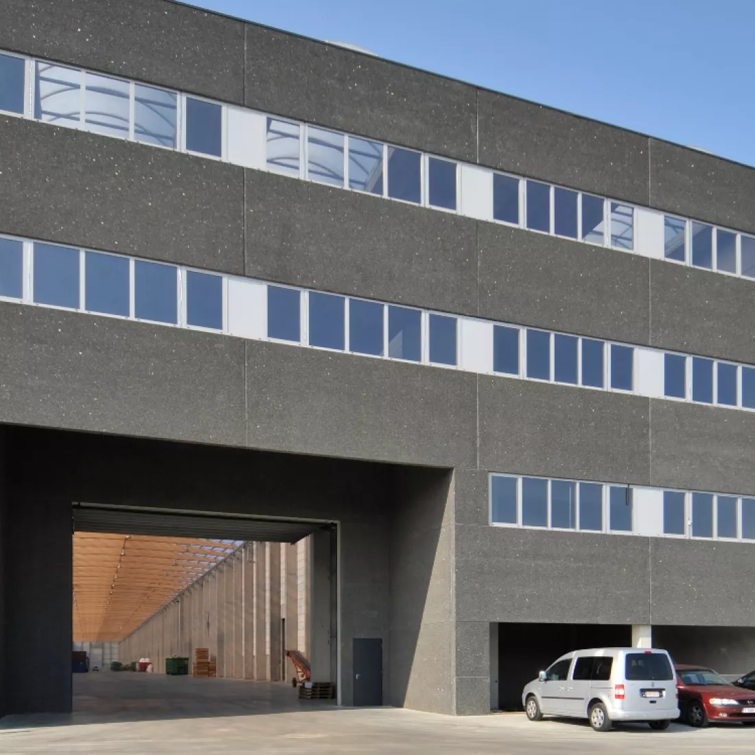 Vooraanzicht kantoor en opslagplaats Scheldenatie. Het kantoor bestaat uit drie verdiepingen. Achteraan bevindt zich de loods met de lichtstraten.