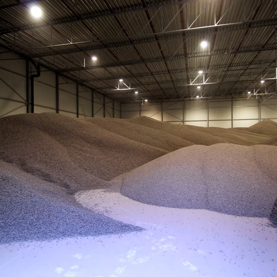 Binnenkant opslagplaats Scheldenatie. Er ligt een zand opgeslagen in deze hal.
