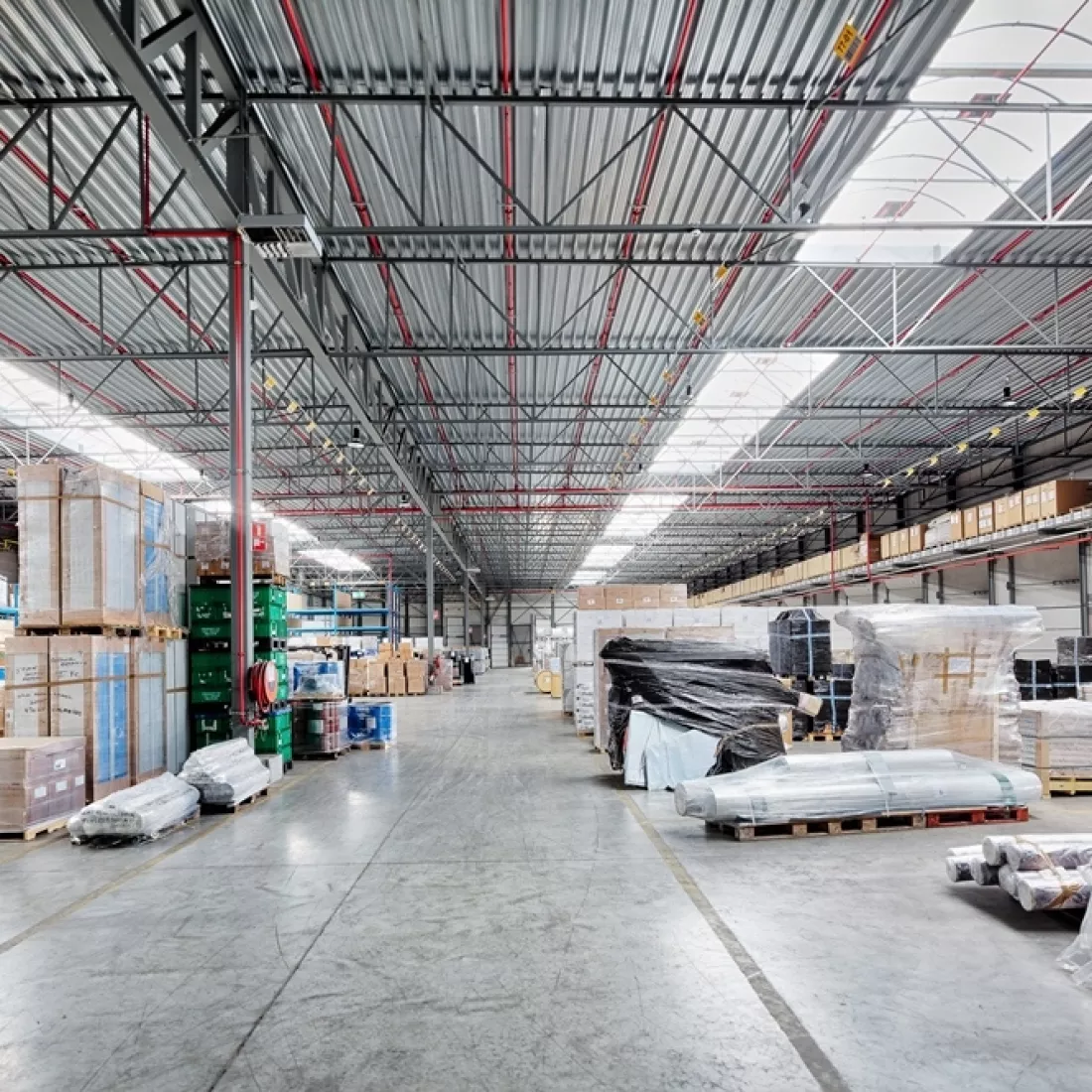 Binnenkant transitmagazijn Transuniverse. Er staan verschillende producten opgeslagen. Het magazijn is opgebouwd met staal.