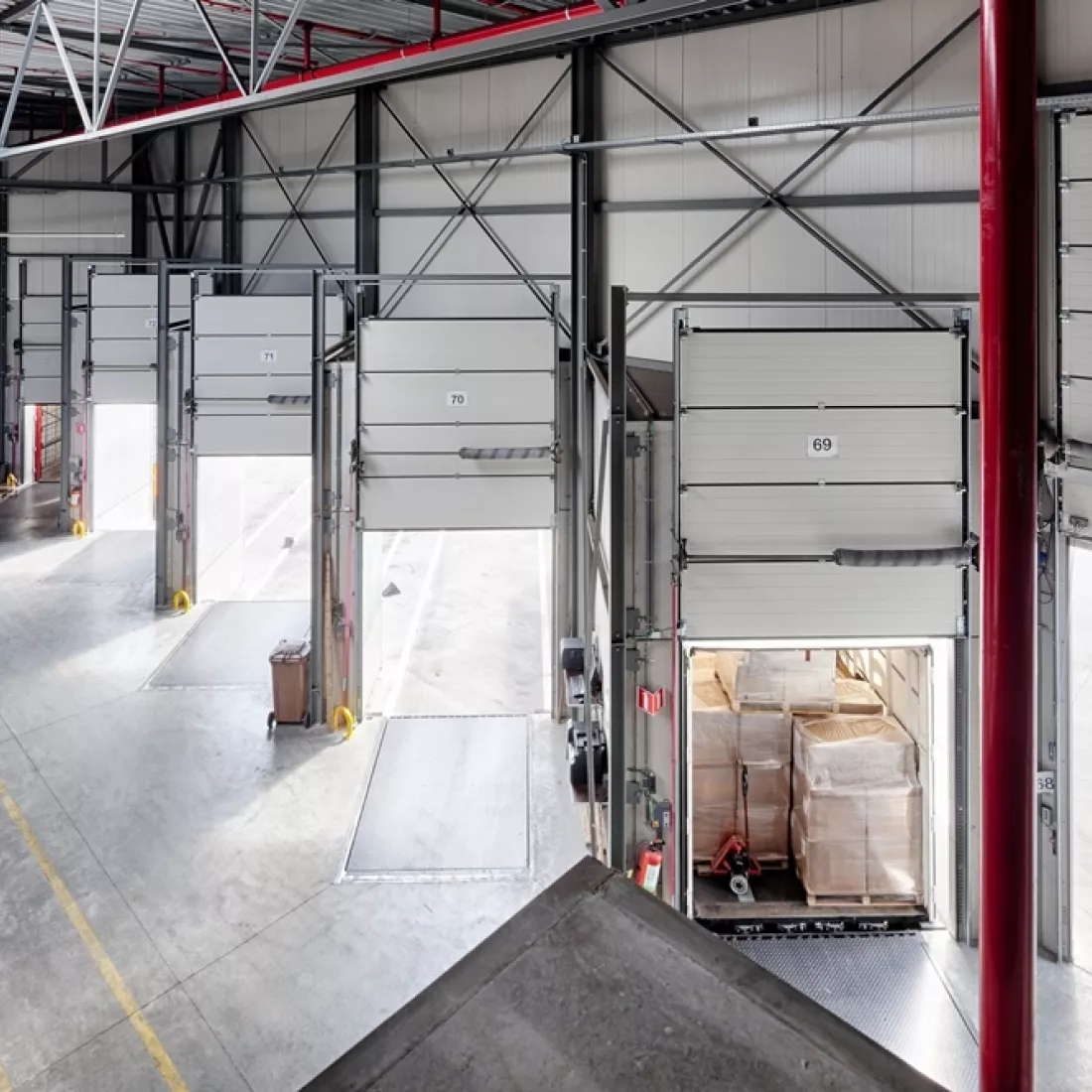 Bovenaanzicht dock voor het laden en lossen van vrachtwagens. De afbeelding is vanuit het magazijn gemaakt. Er is één vrachtwagen aan het laden.