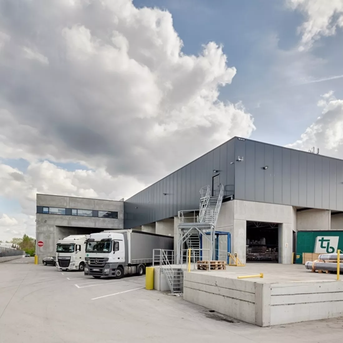 Zijaanzicht transitmagazijn en kantoor Transuniverse. Aan beide kanten van het gebouw bevindt er zich een dock voor het laden en lossen van vrachtwagens. Links bovenaan bevindt zich het kantoor.