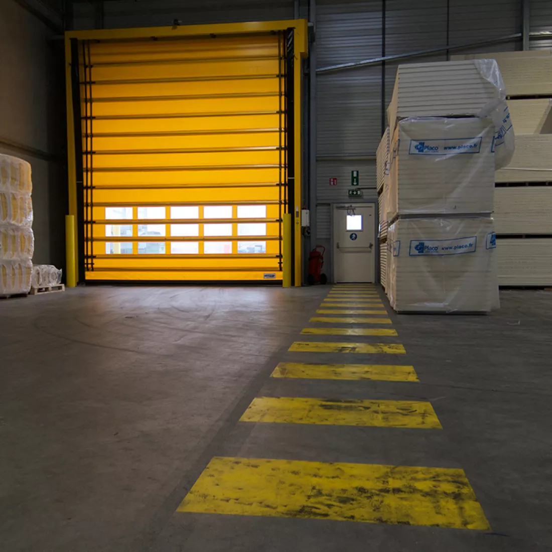 Binnenkant magazijn Saint Gobain. Links bevat het magazijn een gele poort.