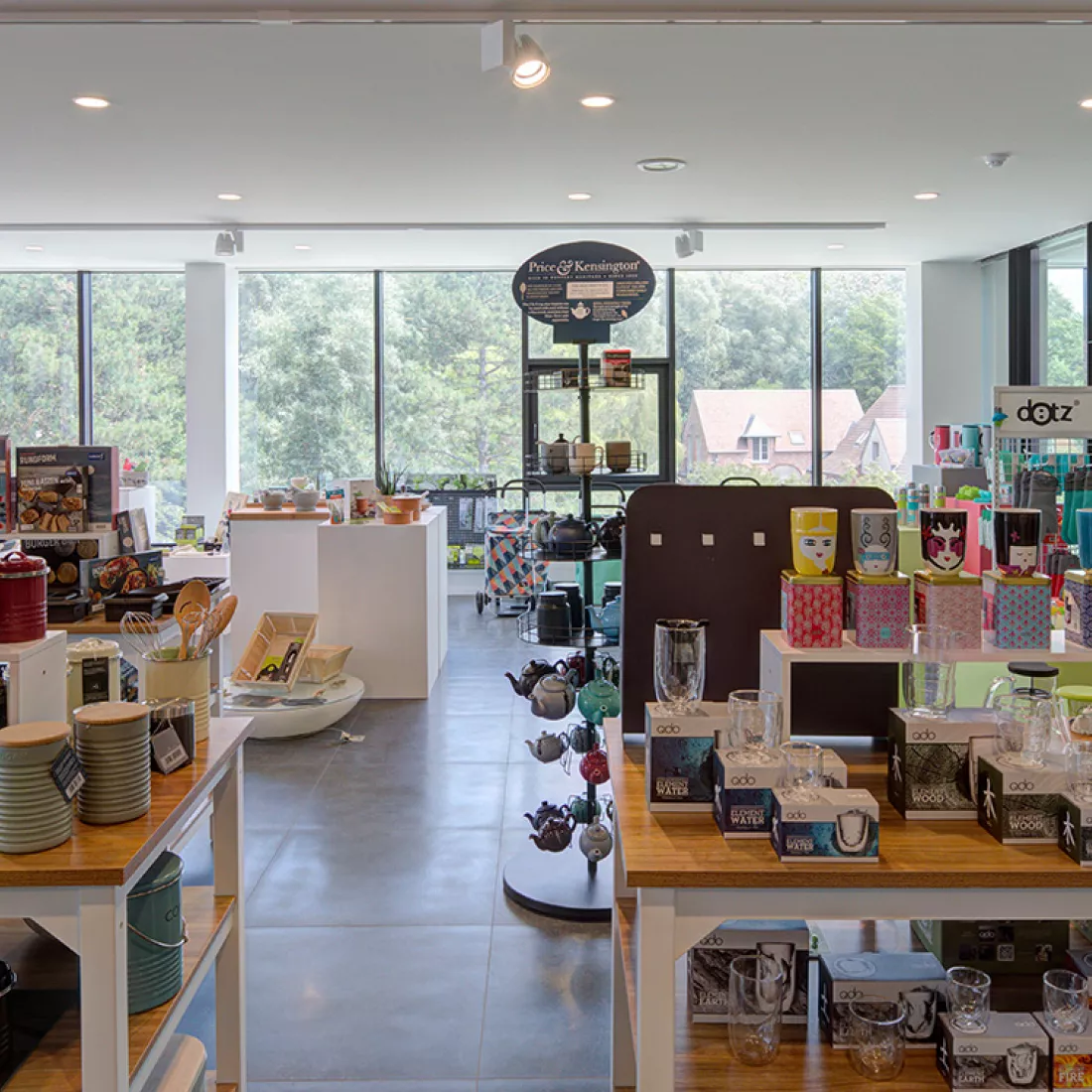 Binnenkant toonzaal/winkel van Point Virgule. Op tafels en in rekken staan de producten uitgestald. Er zijn veel stalenramen.