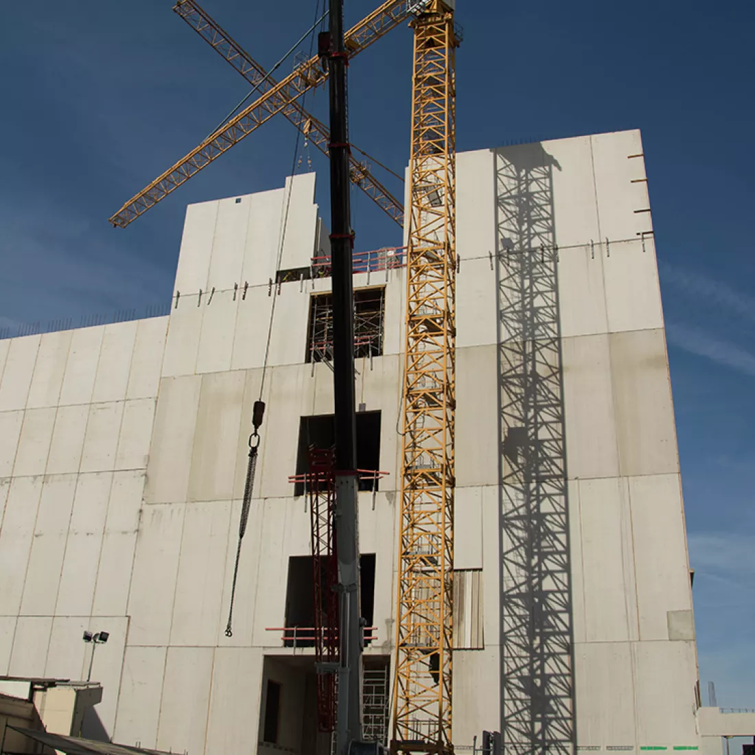 Nieuwbouw Milcobel in opbouw. Op de afbeelding bevat het gebouw vijf verdiepingen. Voor het gebouw staat een gele kraan.