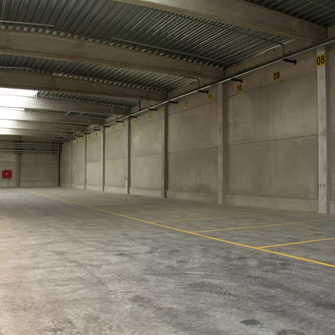 Binnenkant Adpo - Adr loods. Op de vloer zijn vakken afgebakend met gele lijnen. Het gebouw bestaat uit beton en staal.