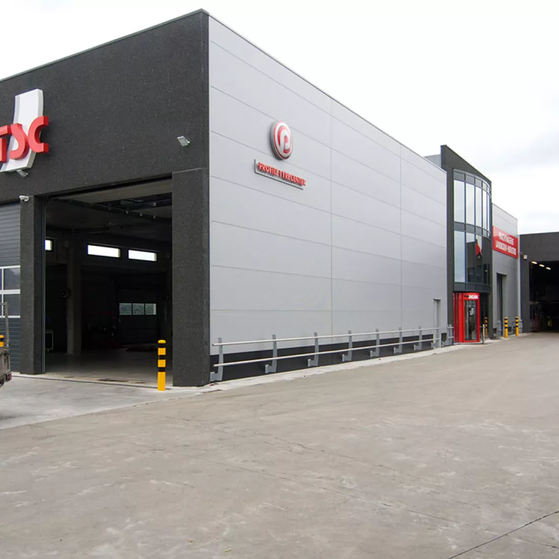 Zijaanzicht TSC. Het gebouw is zwart en bevat rechts ook grijze platen.