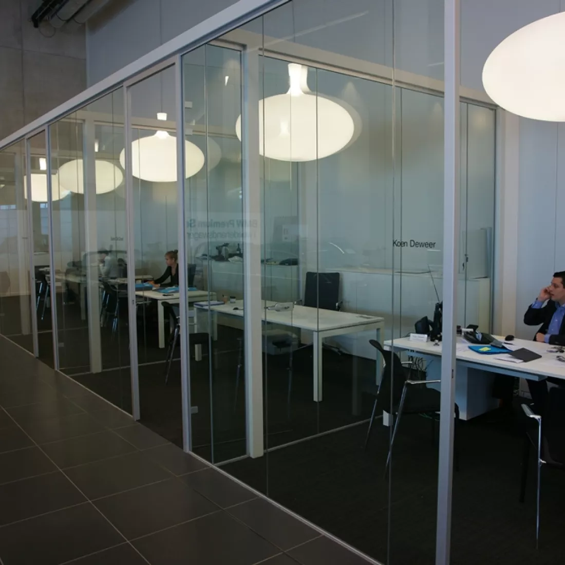 Binnenkant Centrauto - kantoren. De kantoren worden van elkaar gescheiden met glazenwanden.