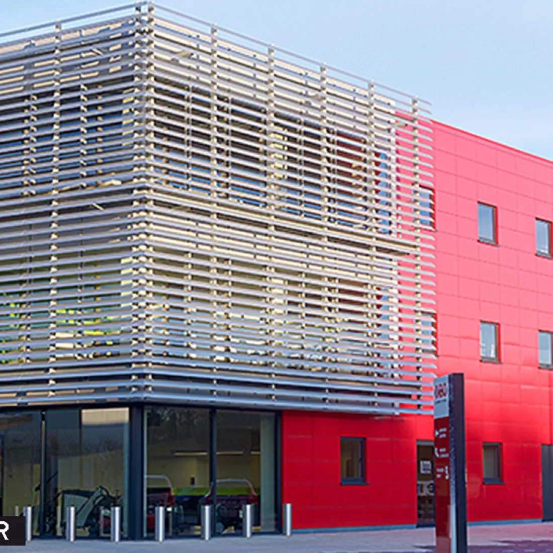 Zijaanzicht werkgebouw DIBO met rode tegels. Het gebouw bevat links en dus aan de voorkant grote ramen. Rechts bevat het gebouw rode tegels.