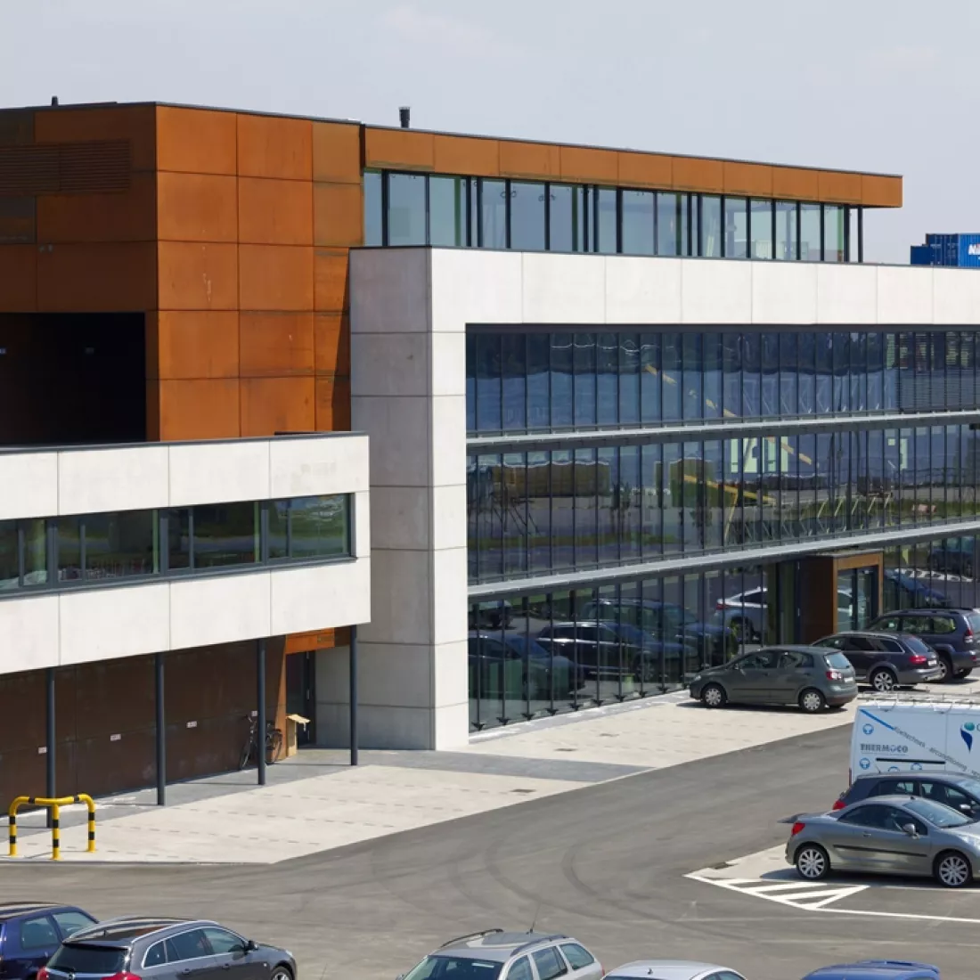 Bovenaanzicht Ivens kantoor. Het gebouw bestaat uit vier verdiepingen. Voor het gebouw bevindt zich een parking.