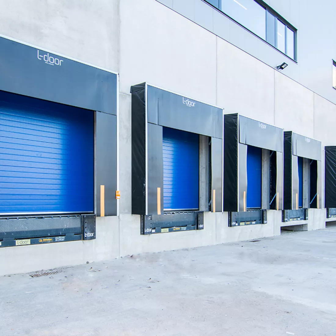Close-up dock - Keetberg Logistics Center. Het dock bestaat uit blauwe poorten en beton.