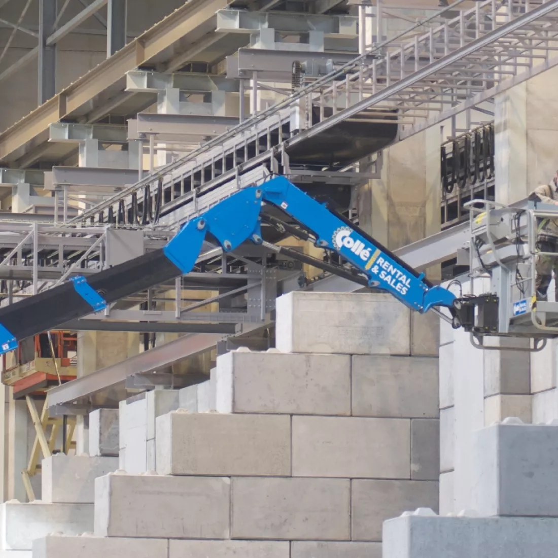 Close-up binnenkant bulkmagazijn Vollers. Er staan verschillende betonblokken. Er is ook een blauwe hoogwerker.