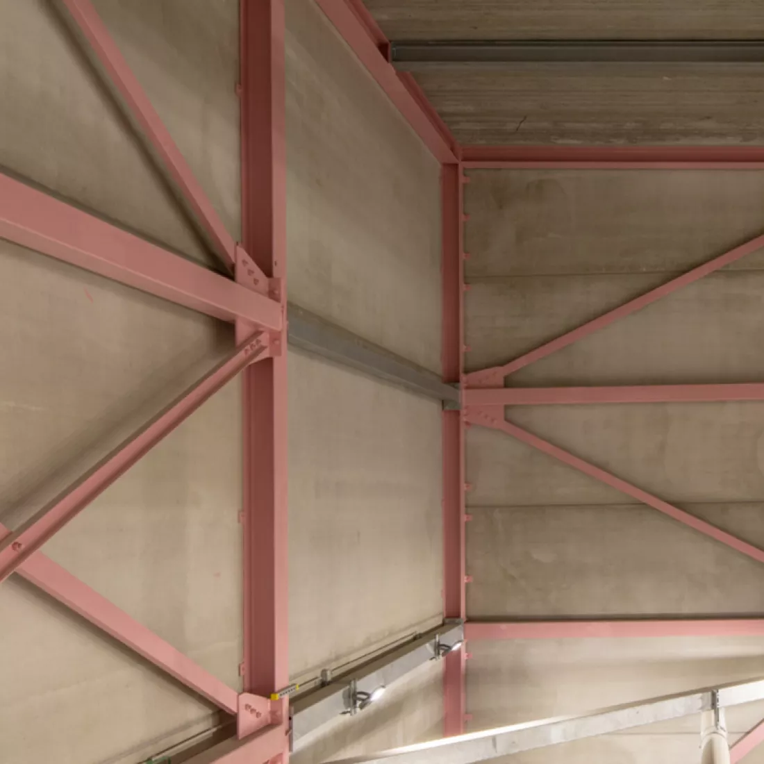 Binnenkant MCC-gebouw Gyproc. Het gebouw is opgebouwd met beton en heeft rode structuur tegen de muren.