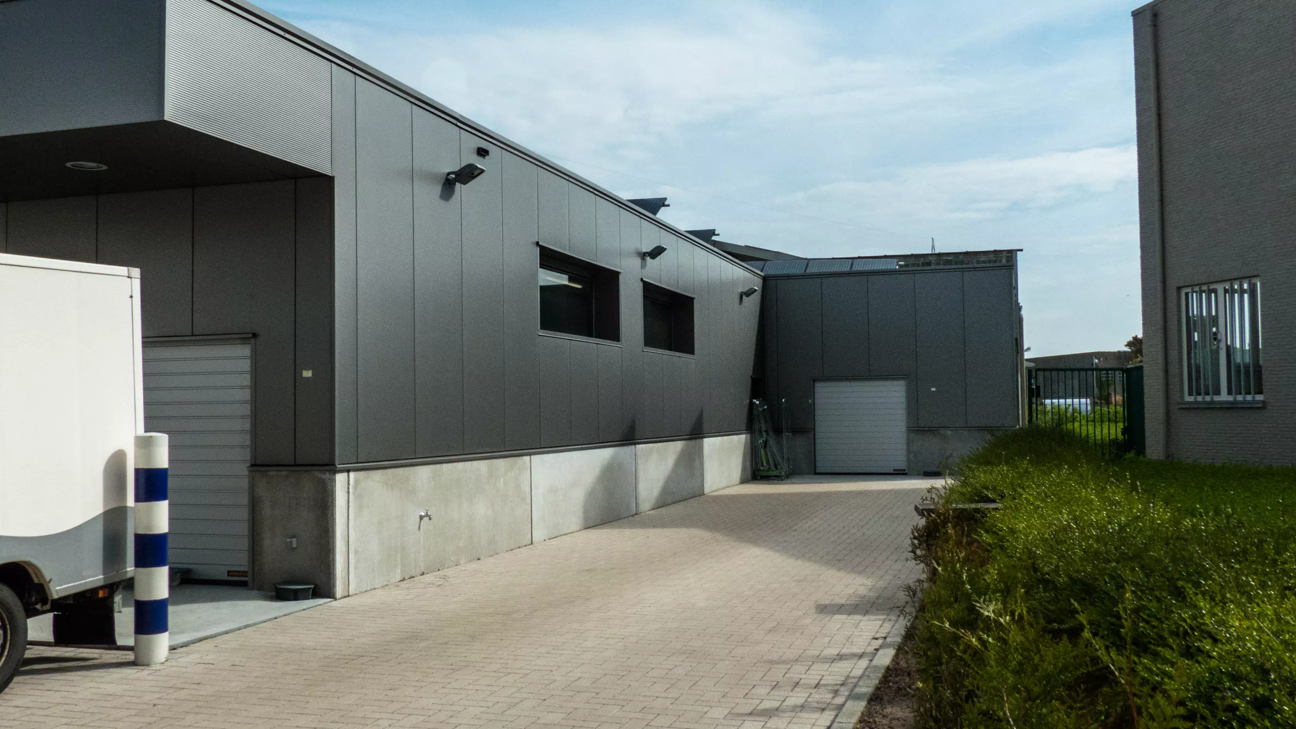 Renovatie bedrijfsgebouw Palethoeve. Het gebouw is zwart met grijze poorten. Tijdens de opbouw werd er staal gebruikt.