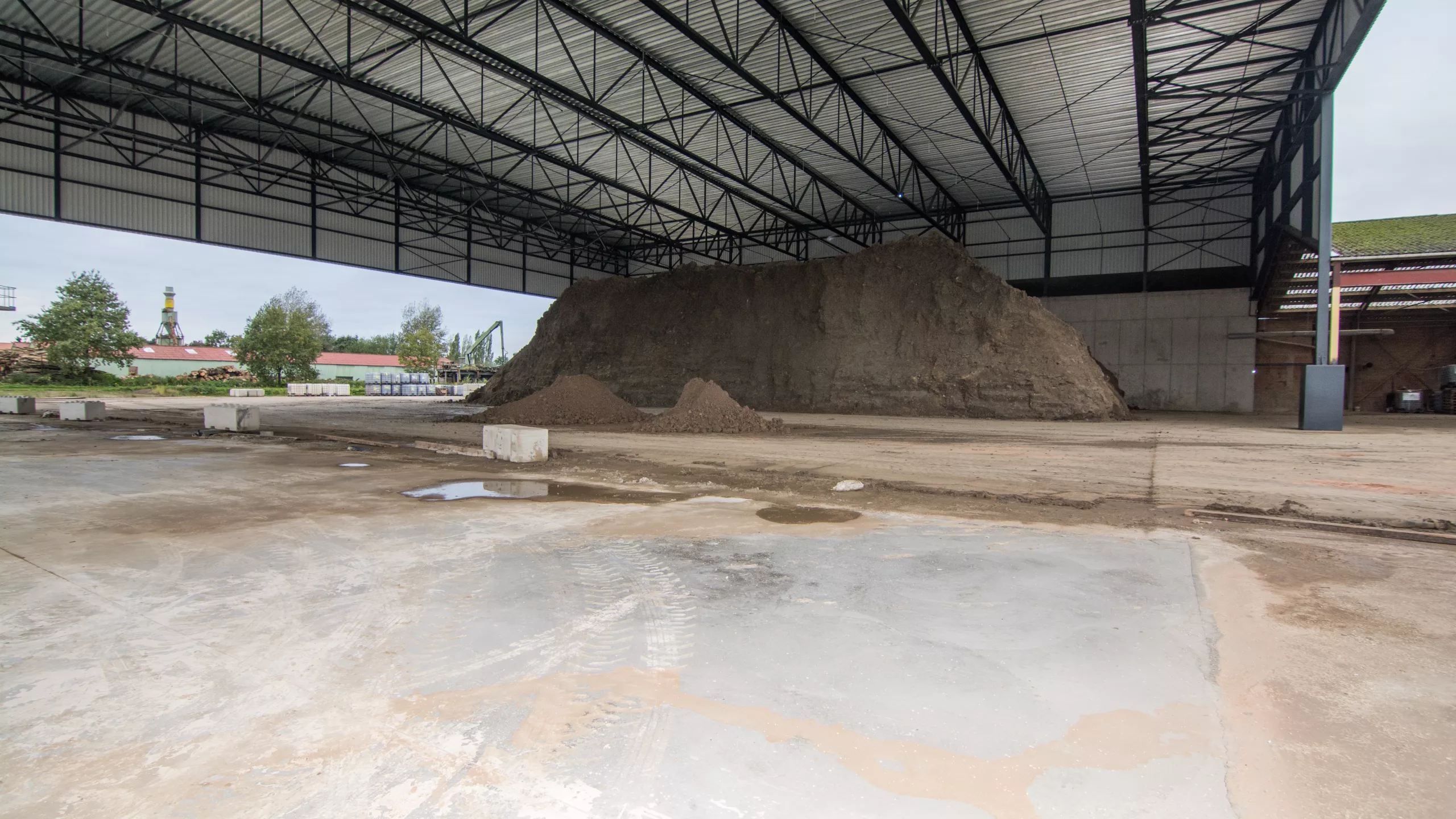 Kleihal met luifel Floren. Tijdens de opbouw is er staal gebruikt. De afbeelding is gemaakt onder de luifel. Er ligt een kleiberg onder de luifel.