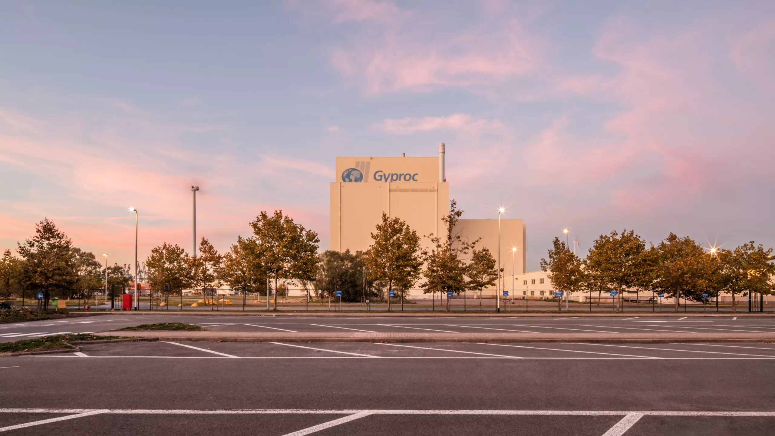 Silotoren en MCC-gebouw Gyproc. Het gebouw is opgebouwd met beton en heeft een witte look langs de buitenkant. Bovenaan staat het logo van Gyproc.