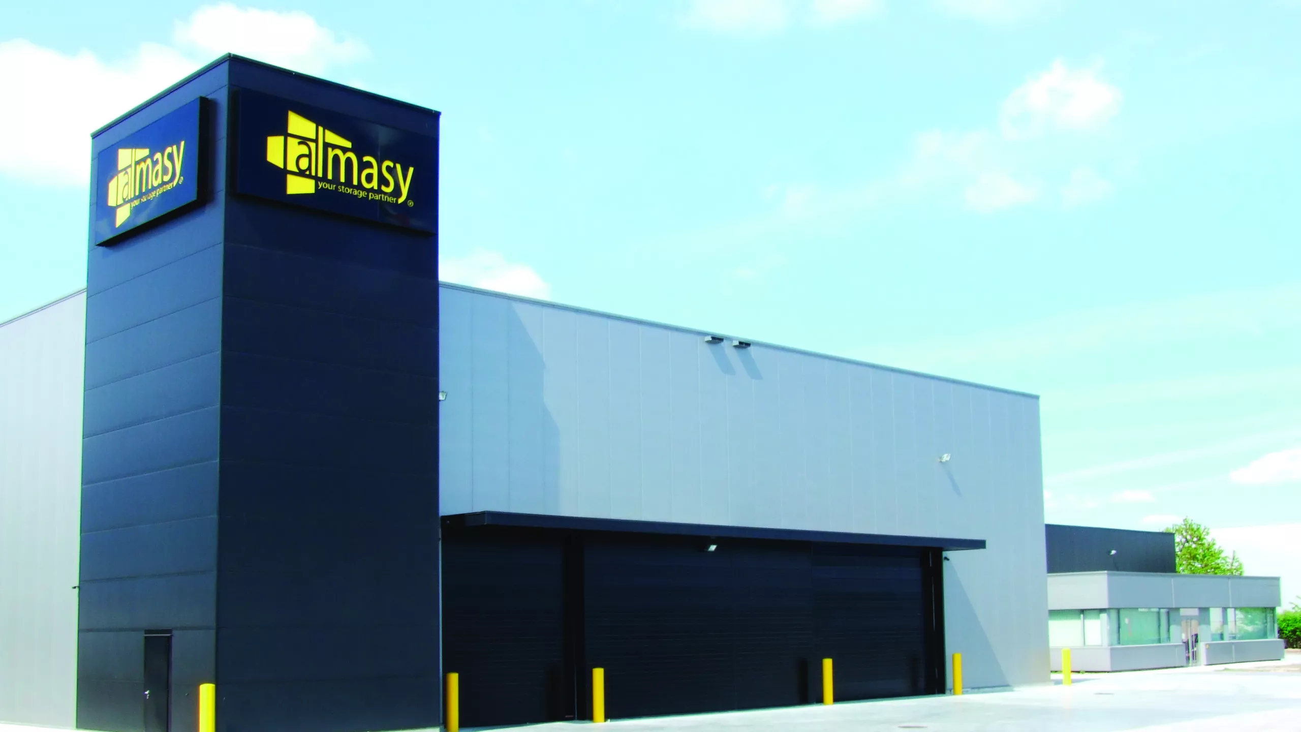Zijaanzicht industriehal Almasy. De hal is grijs met zwart en gemaakt uit staal.