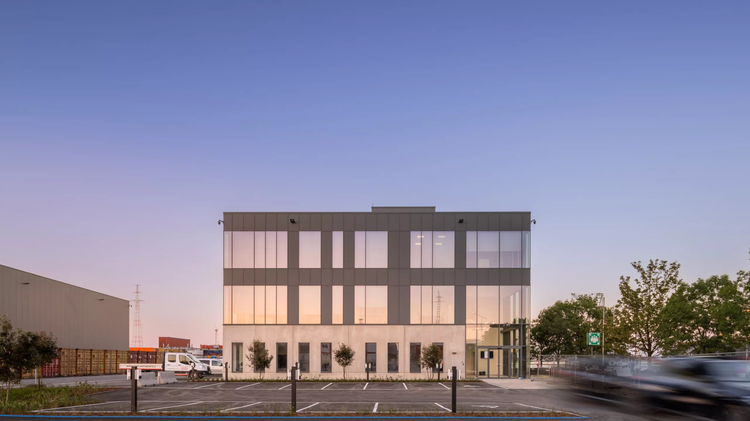 EDR kantoor. Het gebouw bestaat uit beton. De afbeelding is een vooraanzicht van het kantoor. Het kantoor bevat ook zwarte platen en veel ramen. Het gebouw bestaat uit drie verdiepingen.