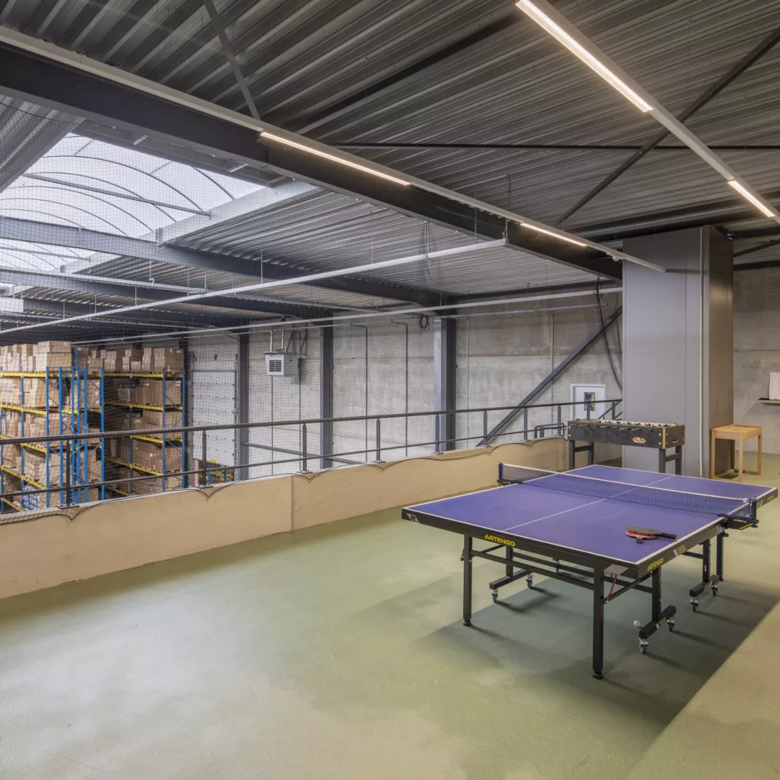 Binnenkant magazijn Ethnicraft - ontspanningsruimte. Er bevindt zich een pingpongtafel in het midden en links een voetbaltafel. De ontspanningsruimte is op de derde verdieping.