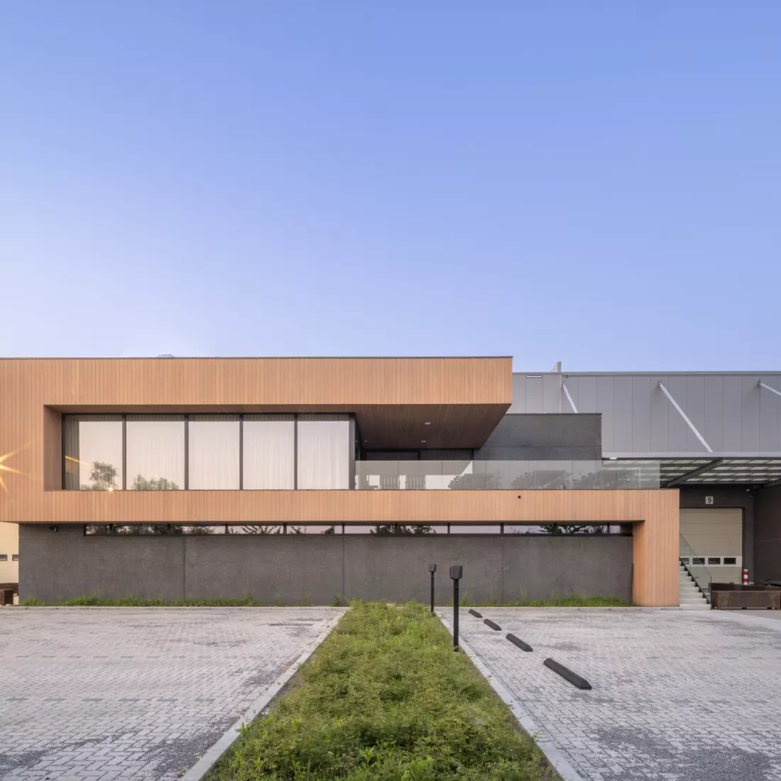 Ethnicraft voorzijde. Dit deel van het gebouw bestaat uit een houtlook. Het heeft twee verdiepingen. Bovenaan bevat het grote ramen en een balkon.