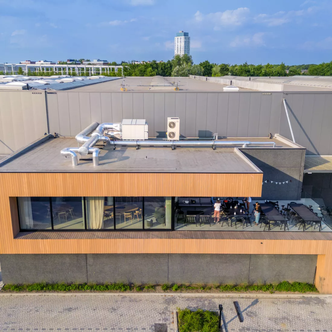 Bovenaanzicht Ethnicraft. Het eerste deel van het gebouw heeft een houtenlook, dit is de refter. Daar achter bevindt zich het magazijn. Het magazijn bestaat uit grijze platen. 