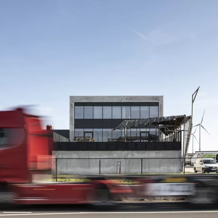 Zijaanzicht sorteer- en recyclagecentrum - Sita kantoor & garage. Het gebouw bestaat uit drie verdiepingen. Op de middelste verdieping bevindt zich een balkon.