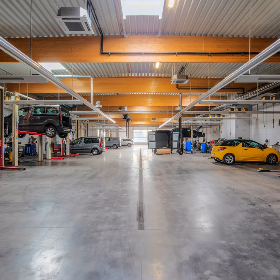 Garage Van Hoecke werkplaats. Achteraan bevindt zich ene poort. Links en rechts staan verschillende werkmaterialen.