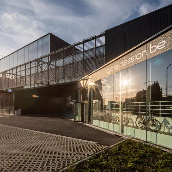 Zijaanzicht bedrijfsunits Futurn. Het gebouw is zwart en bevat veel ramen. Er is op de gelijkvloers een doorgang voor naar de parking te gaan. Het gebouw is gemaakt uit staal.