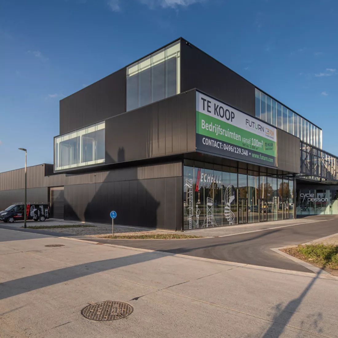 Zijaanzicht bedrijfsunits Futurn. Het is een zwart gebouw gemaakt uit staal en bevat veel ramen. Het gebouw heeft drie verdiepingen.