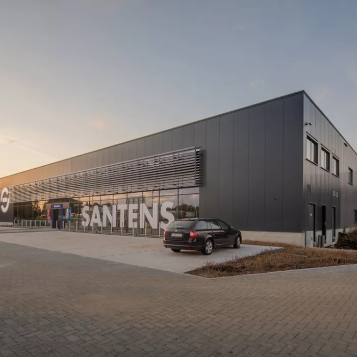 Zijaanzicht bedrijfsunit Immo Bolckmans Geelseweg. Het is een zwart gebouw gemaakt uit staal en met veel stalen ramen. Voor het gebouw is parking voorzien.