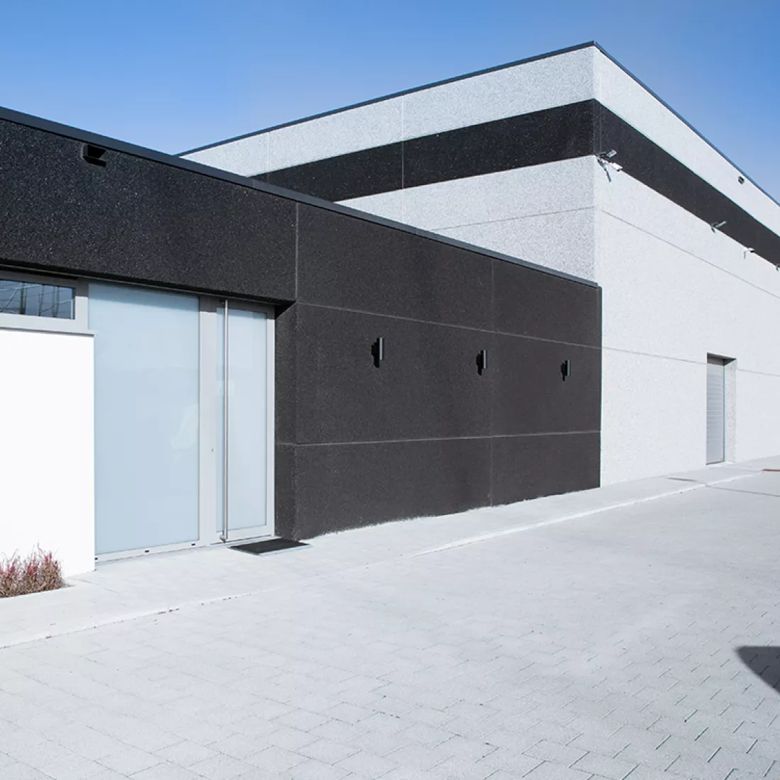 Zijaanzicht magazijn Veratho. Het gebouw is zwart met wit.