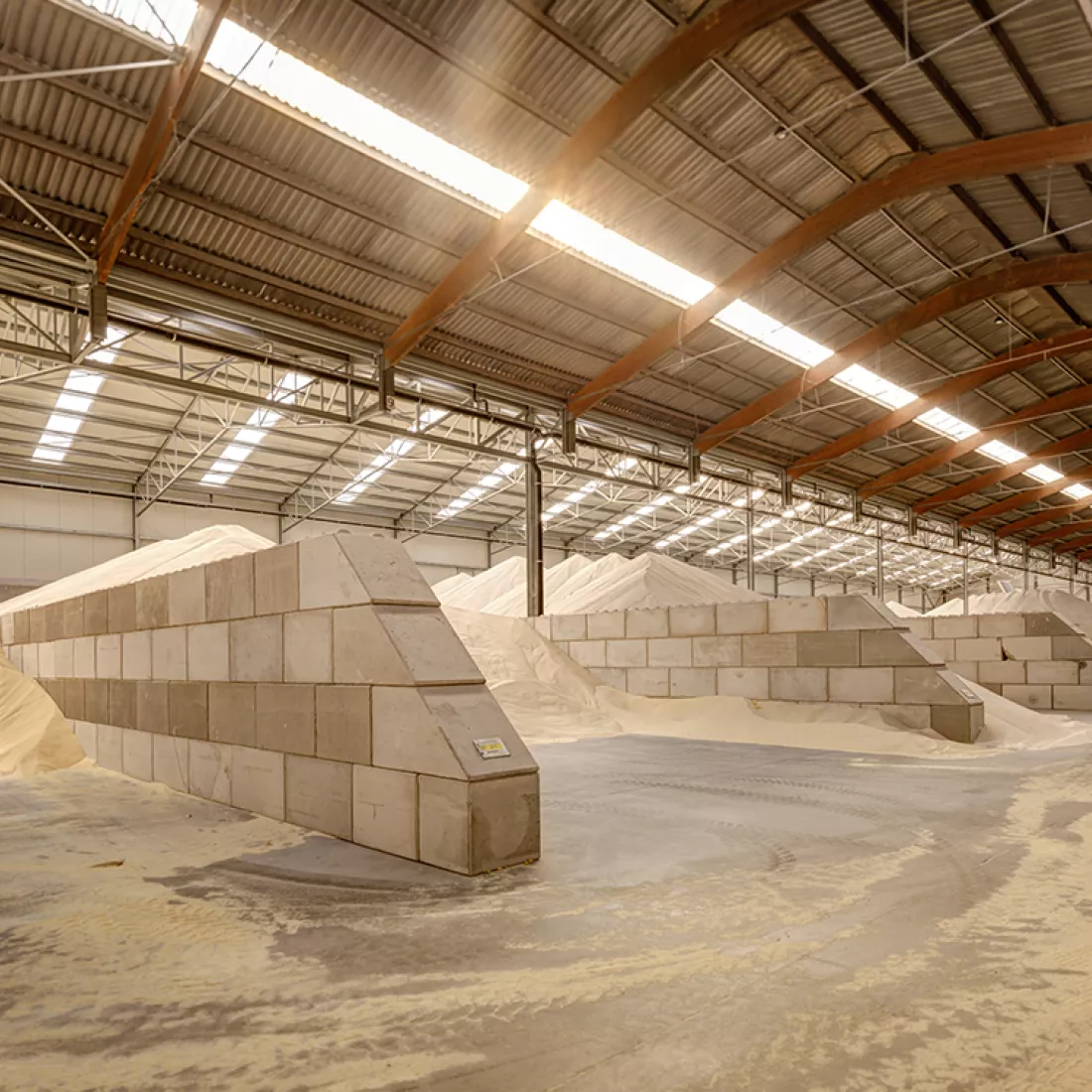 Binnenkant uitbreiding loods Depré. De loods is gebouwd met staal. In de loods liggen producten zoals veevoeding opgeslagen.