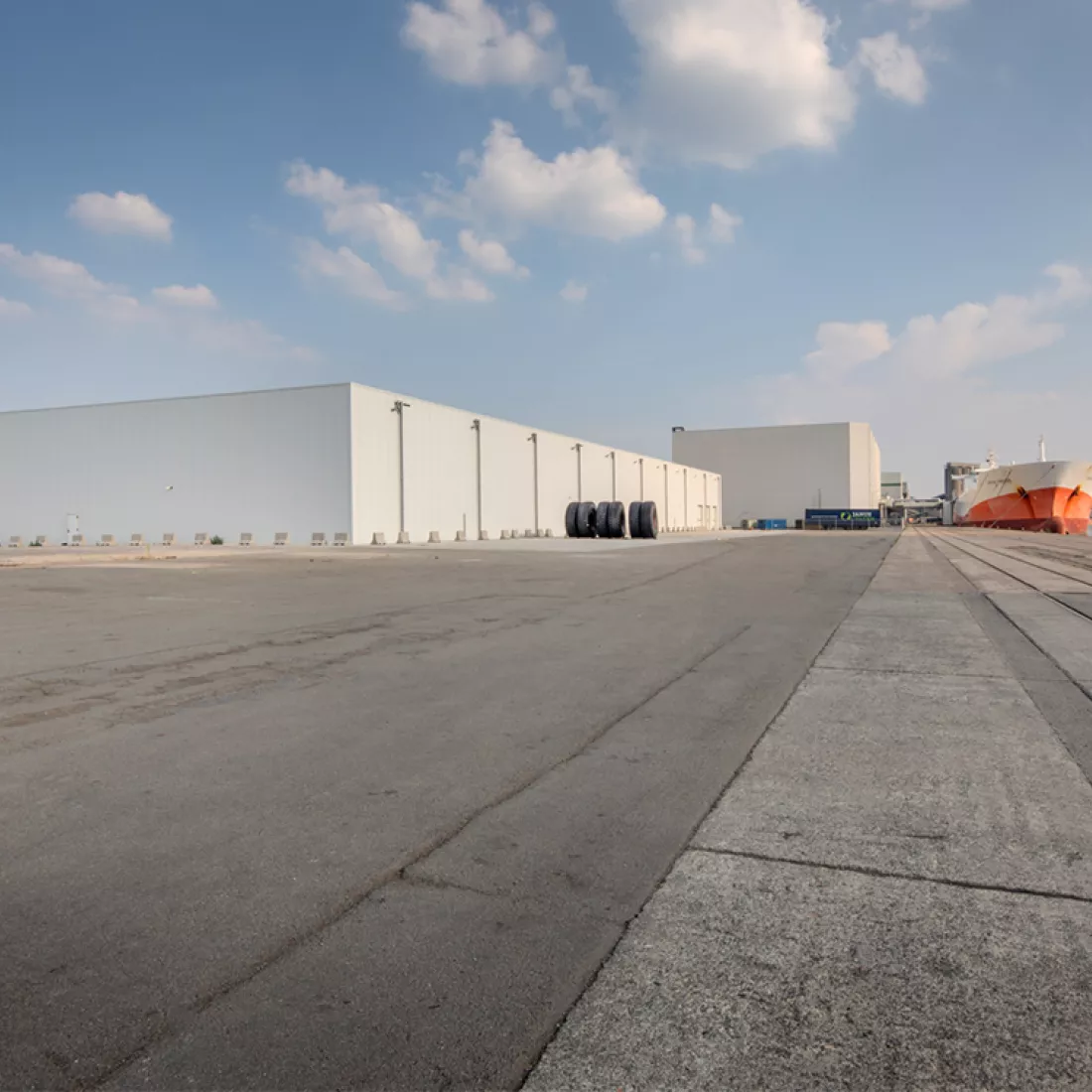 Citrosuco diepvriesloods. Het gebouw ligt in het havengebied. Rechts ligt het kanaal. Links staat de witte diepvriesloods.