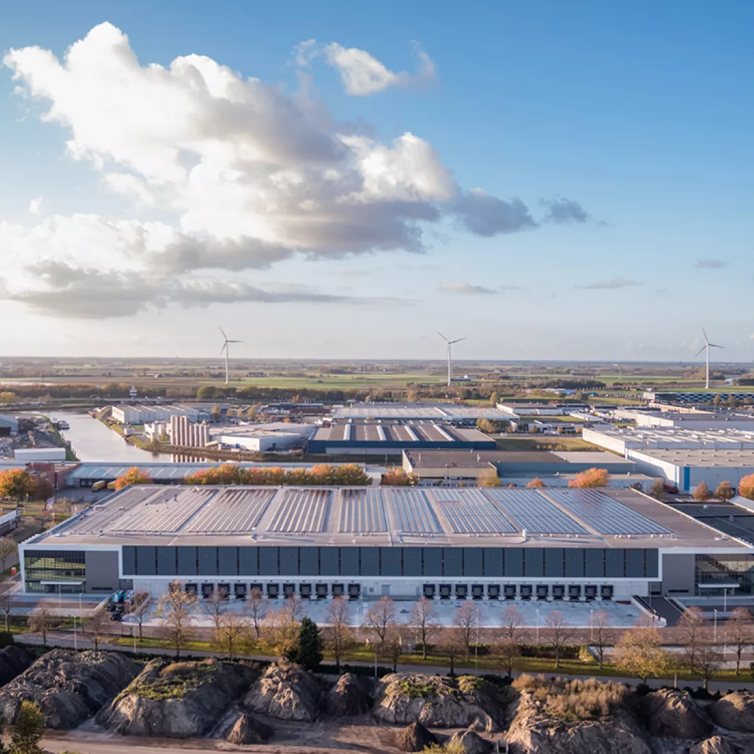 Bovenaanzicht gebouw DC Braak. Het gebouw bevat bovenaan zonnepanelen. In het midden van het gebouw bevindt het dock. Het gebouw heeft zowel rechts als links grote ramen.