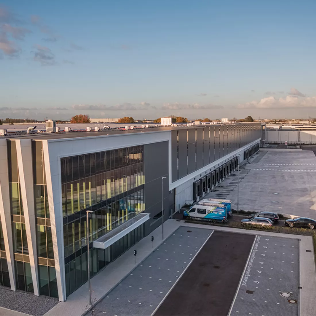 Bovenaanzicht gebouw - DC Braak. De aafbeelding is aan de zijkant gemaakt. Links bevat het gebouw grote ramen. Het gebouw bestaat uit vier verdiepingen. Rechts bevindt zich een dock. Voor het linkerdeel bevinden zich parkeerplaatsen.